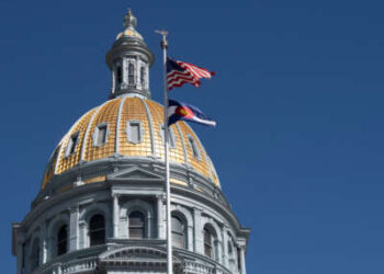 La bandera del estado de Estados Unidos y Colorado vuela frente al domo en la capital del estado de Colorado en Denver, Colorado, el 25 de marzo de 2025.