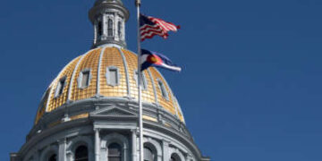 La bandera del estado de Estados Unidos y Colorado vuela frente al domo en la capital del estado de Colorado en Denver, Colorado, el 25 de marzo de 2025.