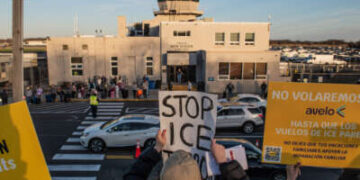 Los manifestantes marchan frente al aeropuerto de Tweed, dejando carteles colgando a lo largo de la cerca que critican a Avelo Airlines por sus planes para ayudar al Departamento de Seguridad Nacional a deportar a los migrantes de Mesa, Arizona, de los Estados Unidos, en New Haven, Connecticut, el 17 de abril de 2025.