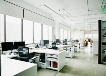 Oficina vacía con múltiples escritorios y computadoras.