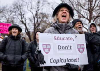 Una persona que tiene un letrero que lee "Educar no capitule" Cantos durante una demostración al aire libre