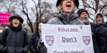 Una persona que tiene un letrero que lee "Educar no capitule" Cantos durante una demostración al aire libre