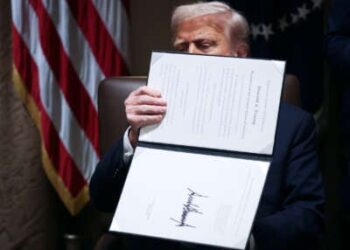 Donald Trump sostiene una orden ejecutiva de lado