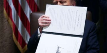 Donald Trump sostiene una orden ejecutiva de lado