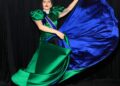 Lady Gaga con un vestido de satén verde y azul detrás del escenario.