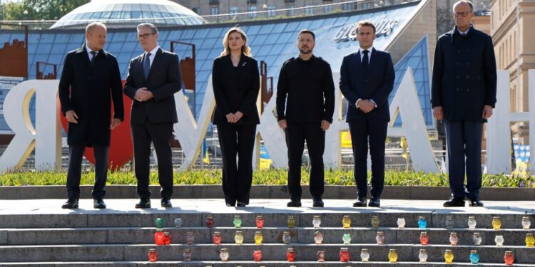 Seis líderes europeos se encuentran en pasos en Kyiv, Ucrania, con velas votivas debajo de ellos.