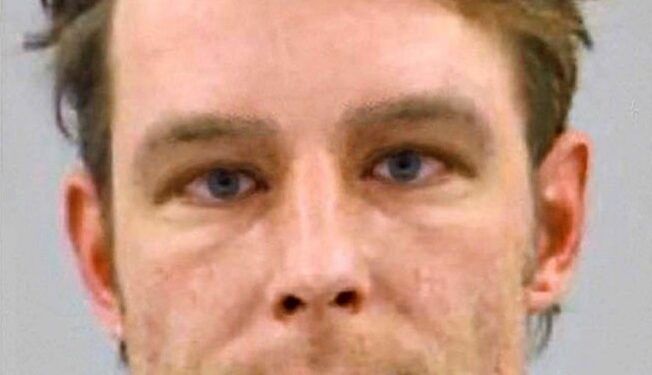 Mugshot de un hombre con cabello castaño claro.