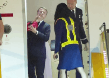 Emmanuel Macron reaccionando a ser empujado por su esposa.