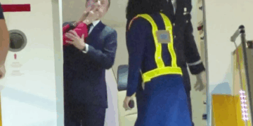 Emmanuel Macron reaccionando a ser empujado por su esposa.