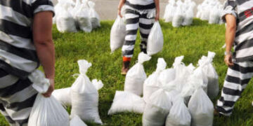 Un equipo de trabajo supervisado de prisioneras de la cárcel llena sacos de arena en preparación para la llegada del huracán Dorian en Florida el 29 de agosto de 2019.