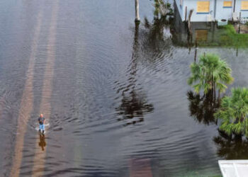 En esta vista aérea, una persona camina por las aguas de la inundación que inundó un vecindario después de que el huracán Milton llegó a tierra el 10 de octubre de 2024 en Punta Gorda, Florida.