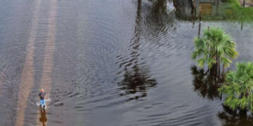 En esta vista aérea, una persona camina por las aguas de la inundación que inundó un vecindario después de que el huracán Milton llegó a tierra el 10 de octubre de 2024 en Punta Gorda, Florida.