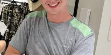 Foto de Jay Slater con una camisa gris y un sombrero de paja.