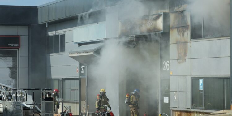 Bomberos en el sitio de un edificio en llamas.