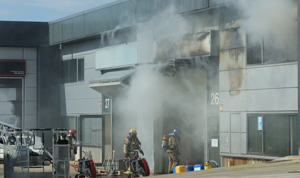 Bomberos en el sitio de un edificio en llamas.