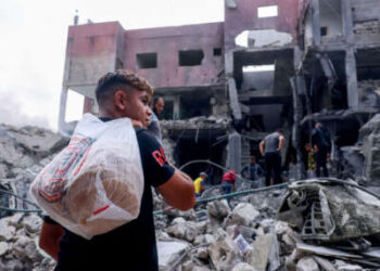 Una juventud palestina lleva pan en medio de los escombros del centro de la ciudad de Khan Yunis en la franja del sur de Gaza después de bombardeos israelíes el 10 de octubre de 2023.