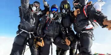 Cuatro escaladores británicos en el Monte Everest Summit, sosteniendo una bandera del Reino Unido.