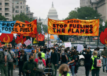 Los manifestantes climáticos marchan a la Casa Blanca el 12 de octubre de 2021 en Washington, DC