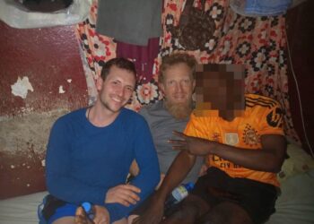 Foto de tres hombres sentados juntos en una celda de la prisión.