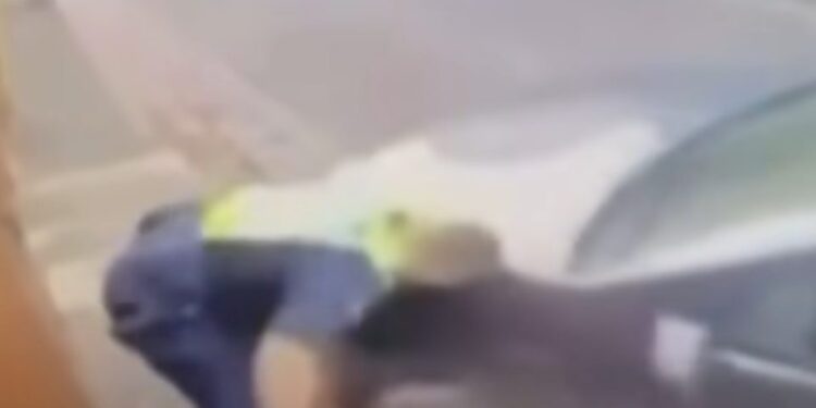 Imagen borrosa de un oficial de policía en el suelo.