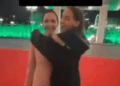 Una mujer abrazando un recorte de tamaño natural del alcalde en una alfombra roja.