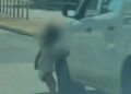 Niño pequeño en pañales corriendo a una carretera.