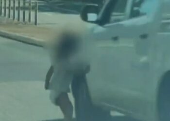 Niño pequeño en pañales corriendo a una carretera.