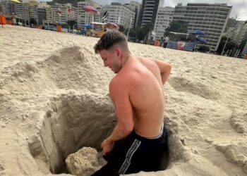 Hombre rescatado de la arena en la playa de Copacabana.