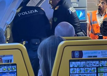 Los oficiales de policía eliminan a los pasajeros disruptivos de un avión.