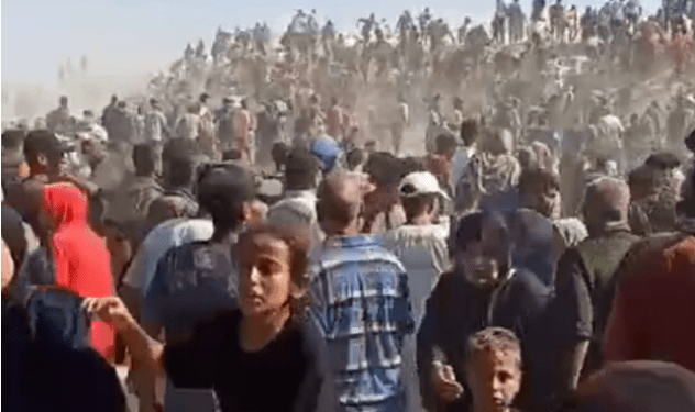 Gran multitud de personas se reunieron, muchas a caballo o camellos en el fondo.