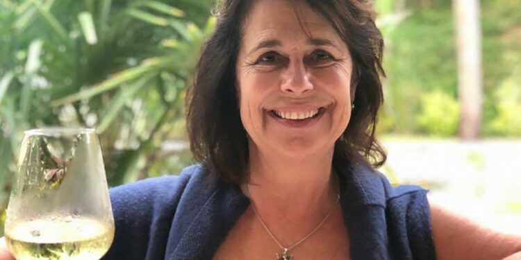 Mujer sosteniendo una copa de vino blanco.