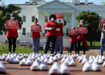 Miembros de National National National United están en protesta entre los zapatos vacíos que representan a las enfermeras que, según dicen, han muerto de Covid-19, en Lafayette Park frente a la Casa Blanca, el 7 de mayo de 2020, en Washington, DC