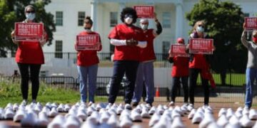 Miembros de National National National United están en protesta entre los zapatos vacíos que representan a las enfermeras que, según dicen, han muerto de Covid-19, en Lafayette Park frente a la Casa Blanca, el 7 de mayo de 2020, en Washington, DC
