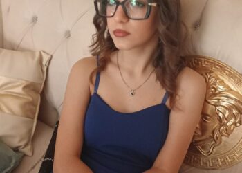 Adolescente con vestido azul y gafas.