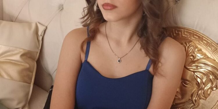 Adolescente con vestido azul y gafas.