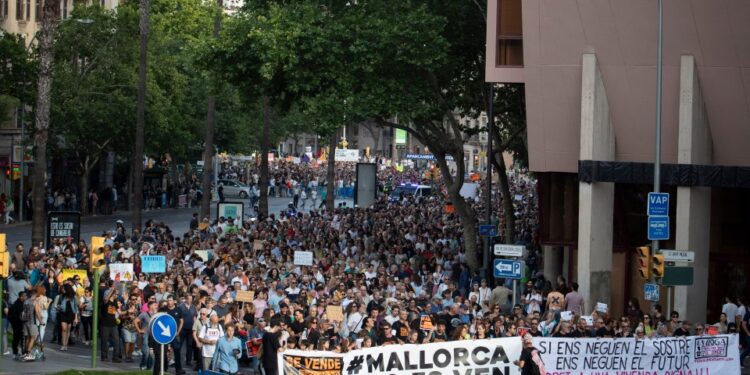 Los manifestantes en Palma de Mallorca sostienen pancartas que leen