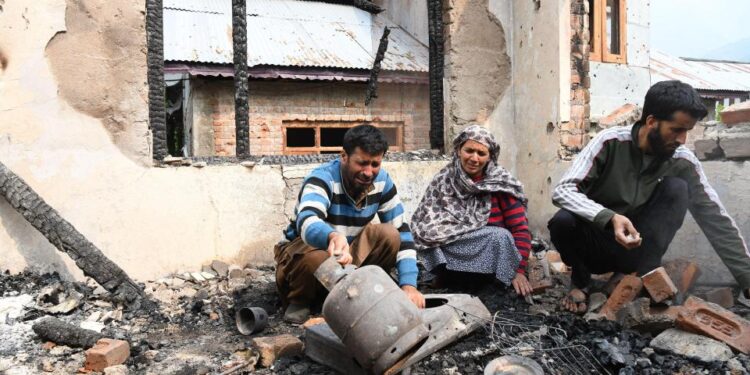 Una familia examina el daño a su hogar después de bombardear.
