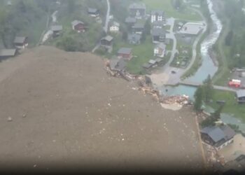Vista aérea de una avalancha que destruye edificios en un pueblo.