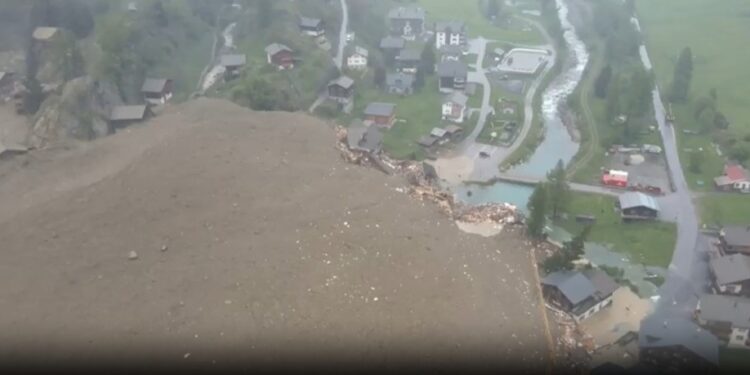 Vista aérea de una avalancha que destruye edificios en un pueblo.