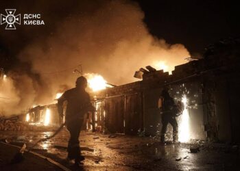 Los bomberos ucranianos extinguen un incendio en un sitio de ataque de misiles en Kyiv.