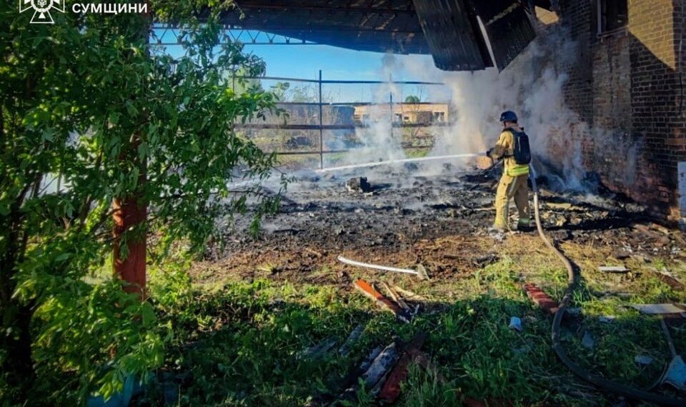 Un bombero extinguiendo un incendio en un edificio dañado.