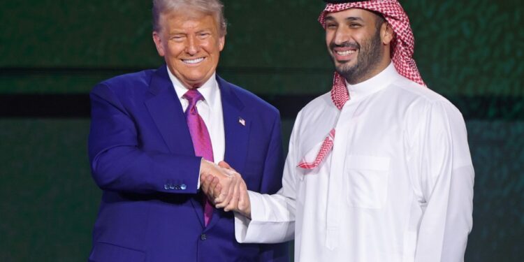 Donald Trump y Mohammed bin Salman dándose la mano en un foro de inversión.