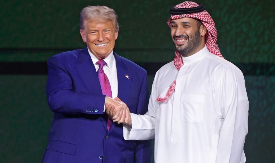 Donald Trump y Mohammed bin Salman dándose la mano en un foro de inversión.