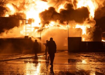 Los bomberos que luchan contra un gran incendio en una estación de servicio.