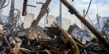 Los bomberos en el sitio de un almacén dañado después de un ataque con aviones no tripulados.