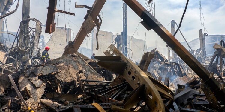 Los bomberos en el sitio de un almacén dañado después de un ataque con aviones no tripulados.