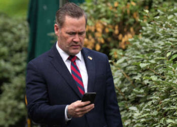 El asesor de seguridad nacional Michael Waltz mira su teléfono mientras se prepara para una entrevista televisiva en la Casa Blanca el 1 de mayo de 2025 en Washington, DC