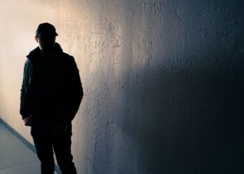 Silueta de un hombre sospechoso en un callejón oscuro.