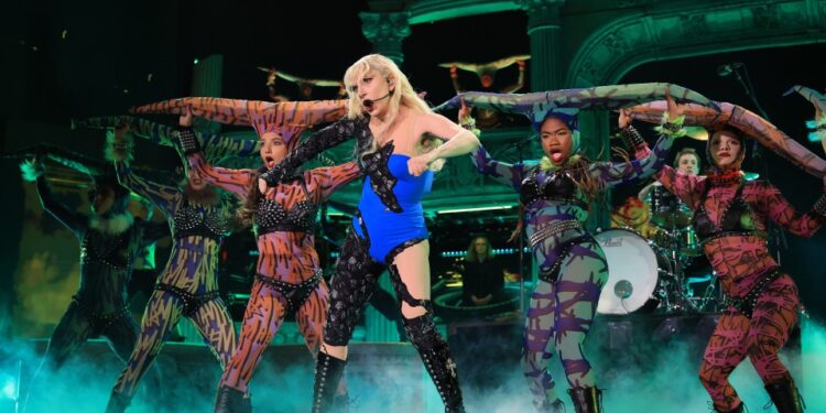 Lady Gaga actuando en el escenario con bailarines de respaldo.