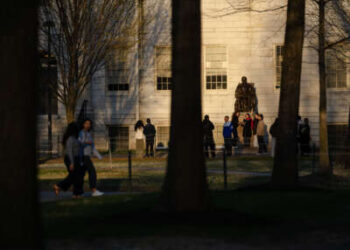La gente se reúne para tomar fotos con la estatua de John Harvard en la Universidad de Harvard el 17 de abril de 2025 en Cambridge, Massachusetts.